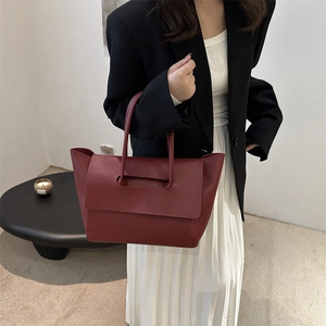 Elegant wine red leather tote bag with unique cutout handles for a minimalist autumn look