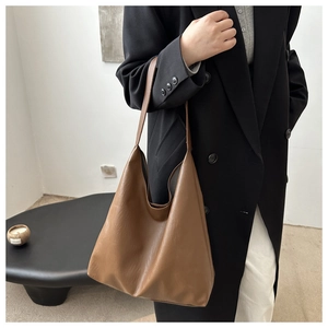 Macro shot of brown faux leather texture and soft pleats on a minimalist tote bag