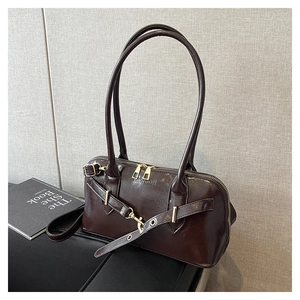 Gros plan du sac vintage marron foncé avec finition brillante effet cuir ciré et boucles dorées