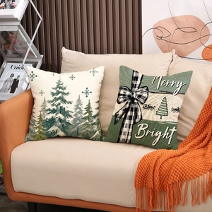 Christmas tree pattern pillow covers on a beige sofa with a bright orange blanket