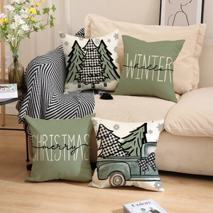 Modern Christmas throw pillows with sage green and cream festive prints on a beige sofa
