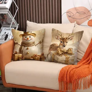 Housses de coussin de Noël avec renne et bonhomme de neige sur un canapé beige