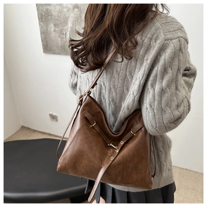 Vue latérale du grand sac cabas rétro en cuir marron avec sangle réglable et boucles métal