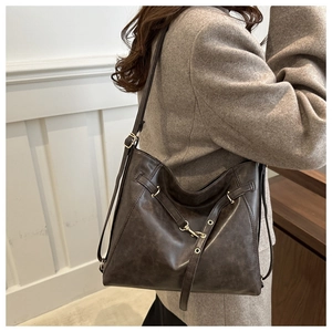 Détail du sac cabas gris anthracite vintage en cuir texturé sur l'épaule du modèle