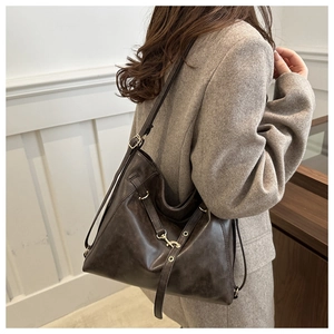 Détail du sac cabas en cuir marron foncé avec texture vintage et boucle dorée