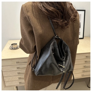 Gros plan d'un sac en cuir noir avec œillets dorés et détails de cordon de serrage
