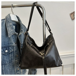Détail d'un sac en similicuir noir avec crochet doré et finitions de sangle chic