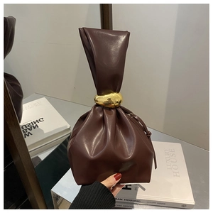 Gros plan sur un sac seau en cuir marron foncé avec fermoir en métal doré