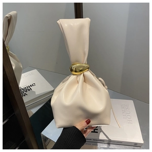 Détail du sac à main plissé crème avec une boucle ronde en métal doré et cuir souple