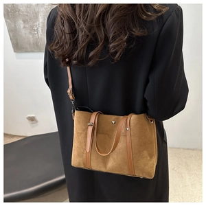 Caramel suede bucket bag with adjustable strap shown on model in black blazer