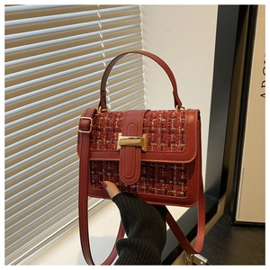 Close-up of red tweed handbag with gold metal clasp and premium leather piping detail