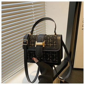 Detailed view of black and gold tweed square bag with elegant metallic buckle