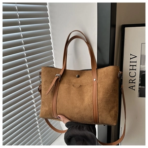 Detailed view of a brown vintage bucket bag with decorative stitching and twin handles