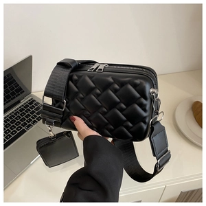 Detail of black quilted crossbody bag with matching mini pouch and nylon strap