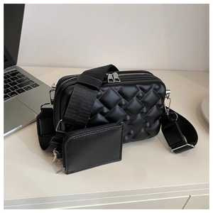 Close-up of black crossbody bag with geometric embossing and mini coin pouch