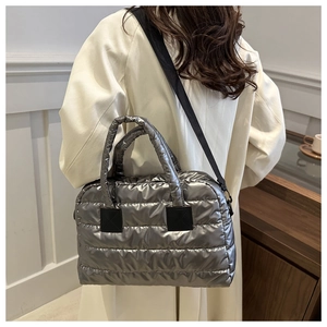 Silver quilted puffer tote bag with metallic finish and black adjustable strap details