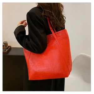 Detail of red crocodile texture tote bag showing spacious design and shoulder strap