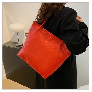 Detail of red crocodile pattern tote bag showing vintage embossed leather texture