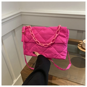 Close-up of rose red quilted crossbody bag with stylish chunky plastic chain detail