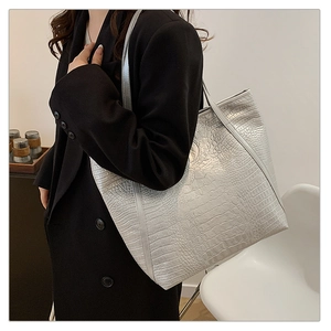 Close-up of a silver crocodile-patterned tote bag showing texture and large capacity
