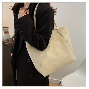 Close-up of retro cream white tote bag with faux crocodile pattern and shoulder strap