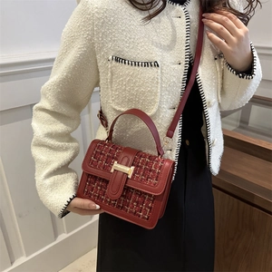 French style red tweed crossbody bag with gold H-buckle shown on a fashion model
