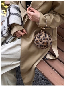 Detail of leopard print plush sphere bag with rhinestone-encrusted gold ring handle