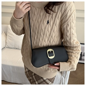 Detail of vintage baguette shoulder bag featuring golden oval buckle and black PU leather