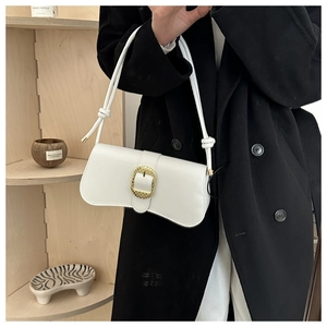 Close-up of a white leather baguette bag with curved base and large gold buckle detail