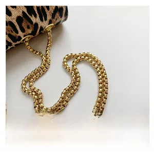 Detail of leopard print handbag featuring a metallic gold square link chain strap