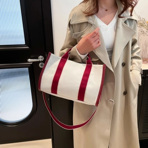 Minimalist canvas tote bag in cream and burgundy with shoulder strap for daily commuting