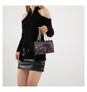 Detail of leopard print handbag with gold chain and oval lock on a black outfit