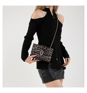 Fashionable leopard print flap crossbody bag with gold chain strap shown on a model