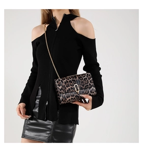 Detail of leopard print flap bag with gold chain strap and U-shaped metal buckle on model