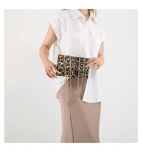 Detail of leopard print flap bag with gold chain strap and U-shaped metal buckle