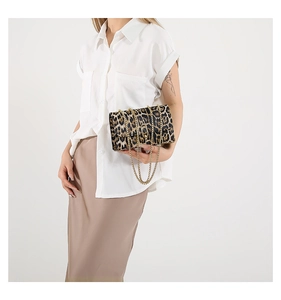 Close-up of leopard print square bag with gold chain strap on female model