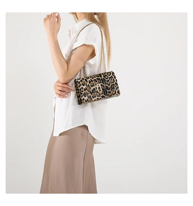 Detail of trendy leopard print shoulder bag with gold chain strap and metal lock