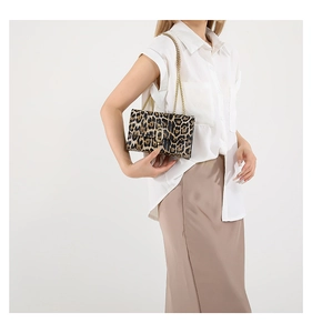 Detail of leopard print shoulder bag with gold chain and U-shaped metal lock closure