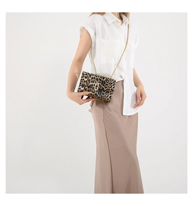 Detail of trendy leopard print shoulder bag with gold chain strap and metal buckle