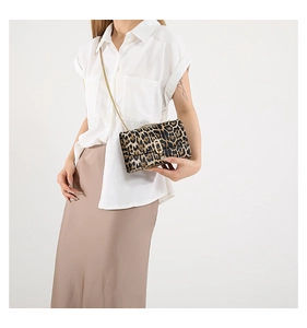 Close-up of leopard print crossbody bag with gold chain strap and metal turn-lock