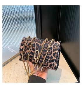 Detail of leopard print crossbody bag with gold chain strap and oval metal lock