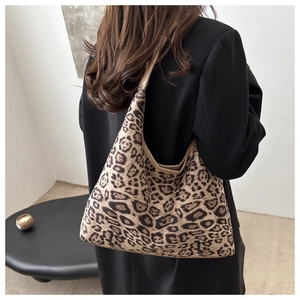 Detail der hobo-tasche mit leopard-print aus strick kombiniert mit schwarzem blazer