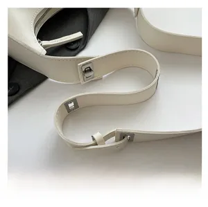 Detail of adjustable ivory white leather shoulder strap with silver buckle hardware