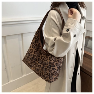 Detail der Hobo-Tasche mit Leopardenmuster und braunem Lederriemen am Modell getragen