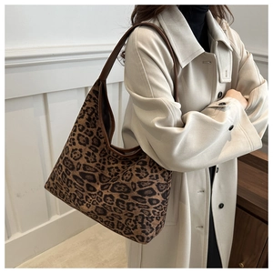 Detail der hobo-tasche mit leopard-muster und braunem lederriemen an der schulter