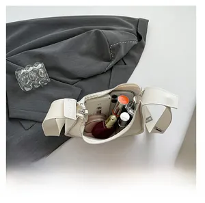 Detail shot of the cream crescent bag interior showing capacity for cosmetics and phone