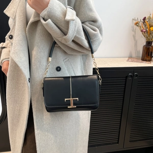 Sac bandoulière minimaliste en cuir noir avec fermoir en T doré et chaîne élégante