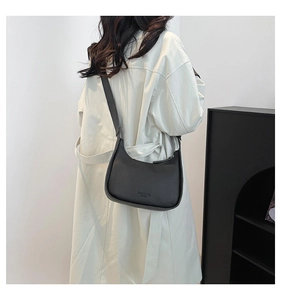 Detail of black matte leather crescent bag featuring fashion bag NEW YORK embossed text