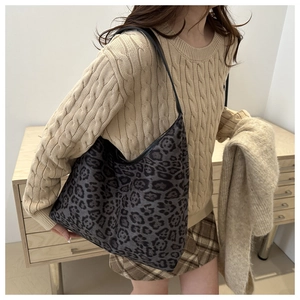 Detailed view of fashionable leopard print hobo shoulder bag styled with winter outfit