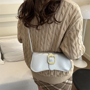 Silver shoulder bag with gold buckle paired with winter knitwear and plaid skirt